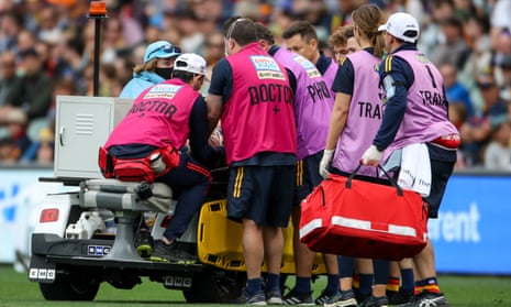An AFL player leaves the field with concussion