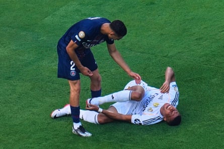 Achraf Hakimi leans over Kylian Mbappé