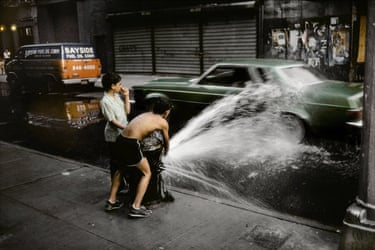 Manhattan, 1985 - two children playing with water spraying from a hydrant over a side street