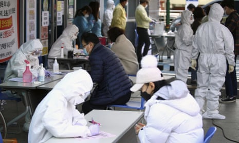 Coronavirus outbreak: workers take details from people suspected of having Covid-19 at a temporary medical centre in Daegu, South Korea.