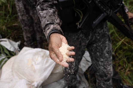 A member of Brazilian security forces holds pellets of explosive in his hand