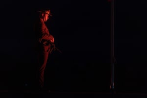 An Australian soldier lit by the glow of a red light during the dawn service in Hobart.