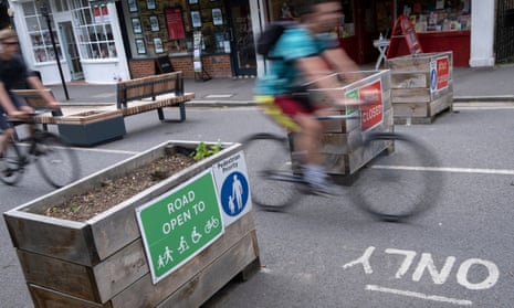 A cyclist passes through barriers installed as part of a low-traffic neighbourhood scheme in London