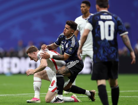 Elliot Anderson of England is pushed by Enzo Fernandez of Argentina.