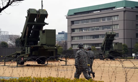 Soldiers walk beside PAC-3 missile launchers on the grounds of the defence ministry in Tokyo on January 30, 2016. 