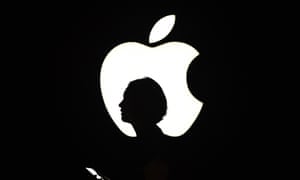 A reporter walks by an Apple logo during a media event in San Francisco, California in September 2015.