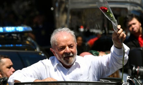 Lula holding a rose in an open-top car