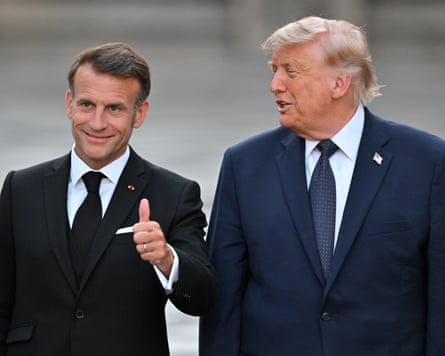 Macron gives a thumbs up as he and Trump walk outside side by side