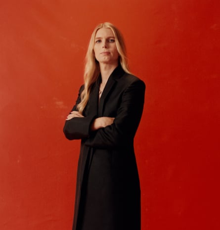 Chelsea Manning in black against red background, photographed in Brooklyn, New York, October 2022