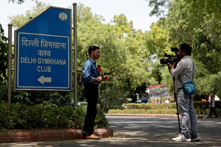 A reporter and cameraman outside the entrance of the exclusive Delhi Gymkhana Club