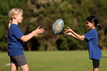 Emily Barry, (L) and Avina Ramji pass the ball at Suburbs Rugby Club.