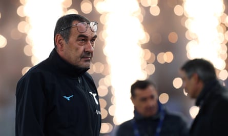 Maurizio Sarri stands against a backdrop of pyrotechnics