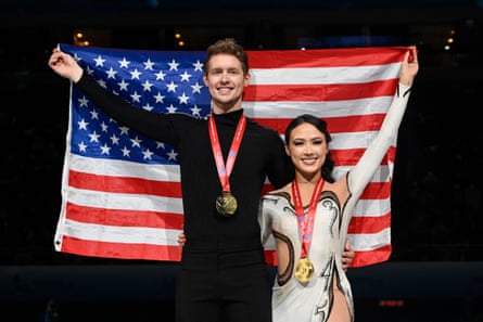 USA's Madison Chock, right, and Evan Bates pose with their country's flag during the ice dance medal ceremony on Saturday in Beijing.