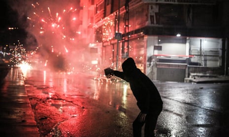 A Kurdish militant fires fireworks towards Turkish riot police during a demonstration in Istanbul after a top Kurdish lawyer was killed in Diyarbakir.