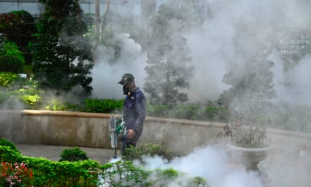 A mask-clad worker disinfects an area in Taipei.