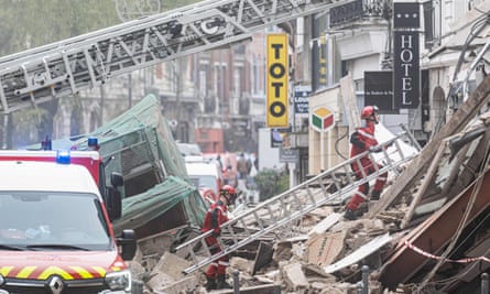 Les pompiers inspectent l'immeuble effondré à Lille samedi.