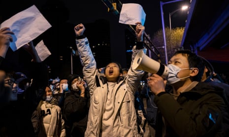 people hold up megaphone and white pieces of paper