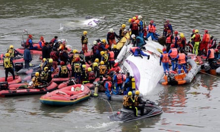 Rescuers carry out rescue operations after a TransAsia plane crashed into a river in New Taipei City.