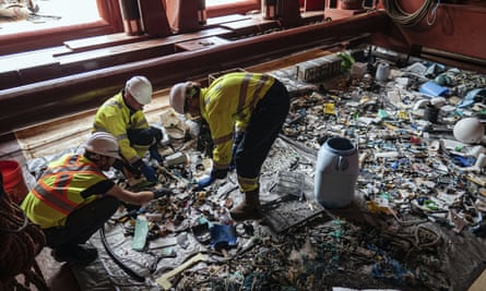Crew members sort through plastic onboard a support vessel in the Pacific.