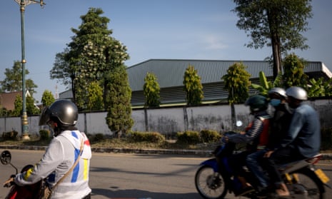 People on mopeds ride past the VK garment factory in Mae Sot, Thailand