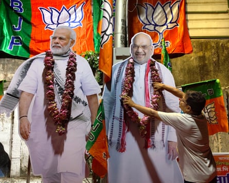 Large cardboard cutouts of Narendra Modi and Amit Shah, surrounded by BJP flags