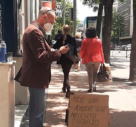 A man with a cardboard sign, looking for work