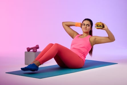 Woman doing sit-ups while holding a cheese-burger.