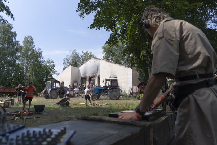 A DJ at work while young volunteers clear the debris.