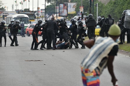 Police beat a demonstrator during a rally of former Ivory Coast President Laurent Gbagbo’s supporters to protest against his absence on the presidential candidates electoral list in Abidjan on 6 August 2020.