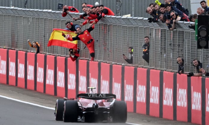 Ferrari crew wave a Spanish flag as Spanish driver Carlos Sainz Jr crosses the finish line first to win the Formula One British Grand Prix