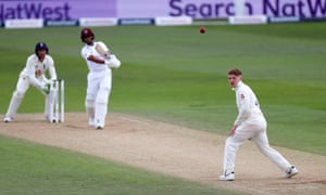 England’s Dom Bess looks on as West Indie’s Shane Dowrich hits the ball back past him for a boundary.
