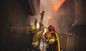 Firefighters fight a blaze in Anaheim Hills, in southern California. Around 8,000 firefighters are working across the state.