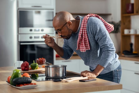 man tasting soup in kitchen at home