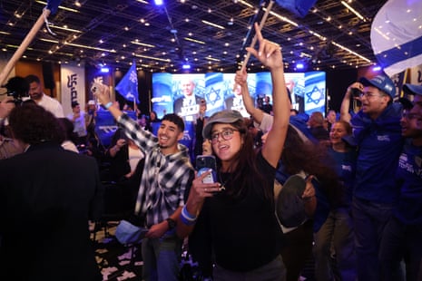 Likud Party supporters cheer and wave blue flags at a rally in Jerusalem