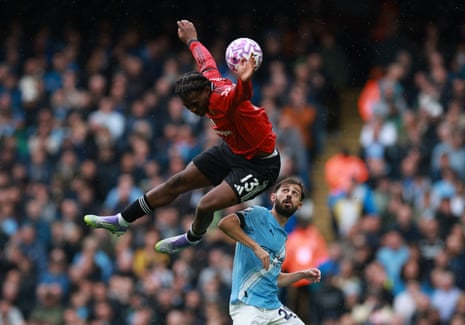 Patrick Dorgu of Manchester United challenges Manchester City’s Bernardo Silva in the air.