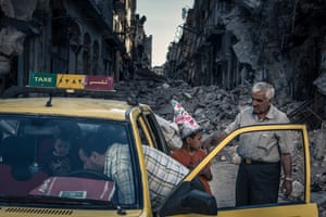 Homs, June 2014: Abu Hisham Abdel Karim and his family bundle salvaged possessions into a taxi.