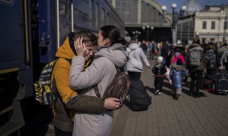 Woman embraces son on rail platform