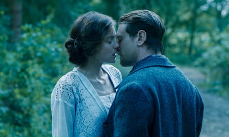Emma Corrin as Lady Chatterley
                  and Jack O'Connell as Mellors on the brink of kissing,
                  outdoors.