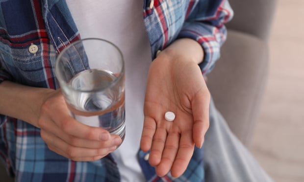Young woman with abortion pill and glass of water indoors