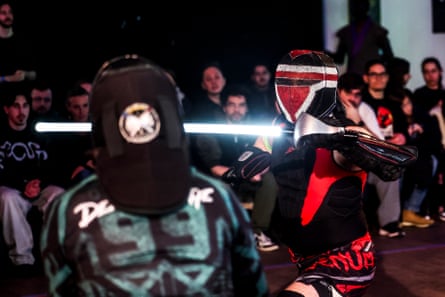 Sébastien Berard fighting an opponent with a lightsaber in front of an audience