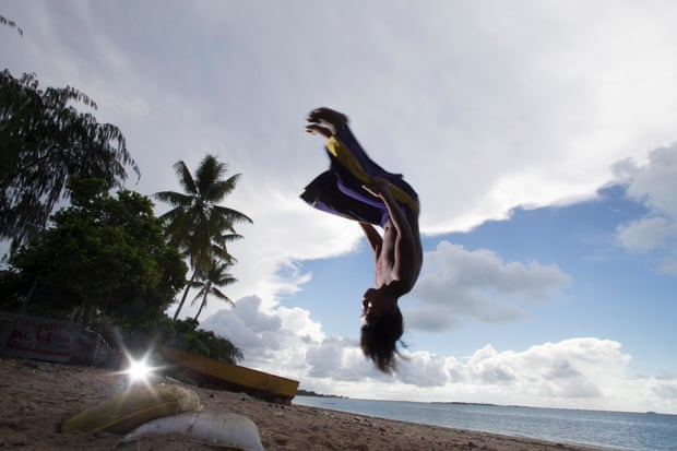 Children from the village of Nanikai on South Tarawa performing acrobatics on the beach.