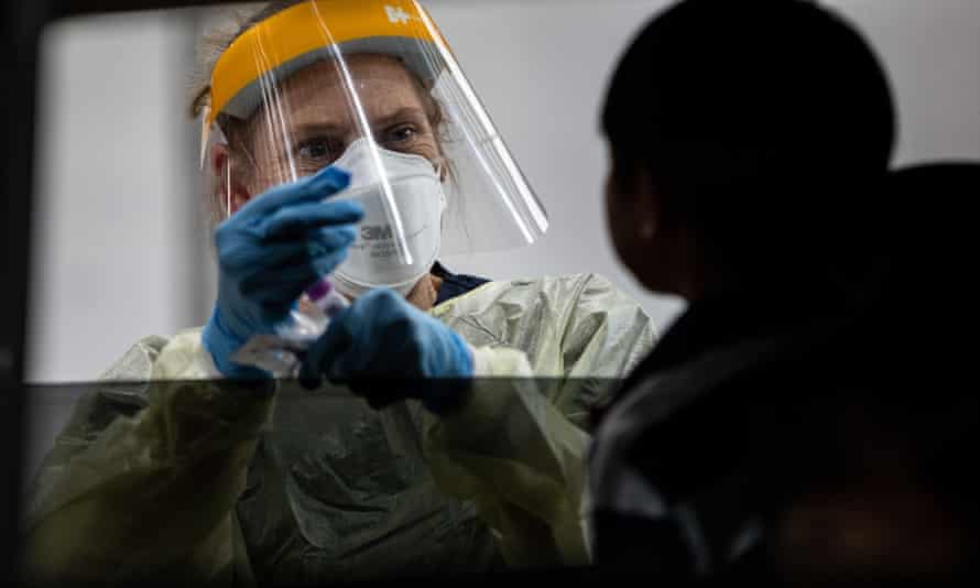 A healthcare worker collects a Covid swab at a testing site in Melbourne