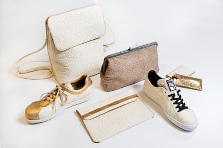 Un set di prodotti in similpelle, tra cui uno zaino, un portafoglio e delle scarpe, realizzati in pelle di ananas, su sfondo bianco.