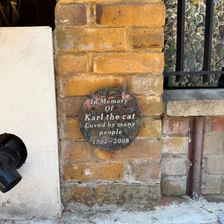 A memorial plaque placed low on a brick wall, saying ‘In memory of Karl the cat Loved by many people 1992-2008’