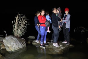 A group of migrants arrives in the US after crossing the Rio Grande in a raft piloted by smugglers in Roma.