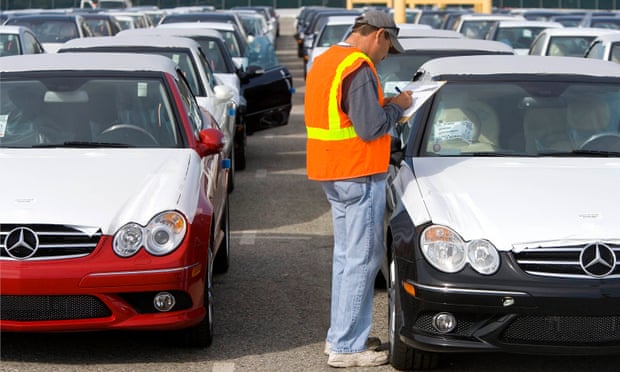 A worker at the Port of Long Beach checks a shipment of Mercedes.