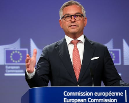 Magnus Brunner at podium with EU flags on background behind him