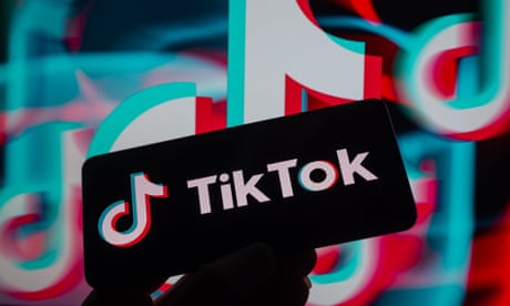 TikTok logo displayed on a smartphone with TikTok icon seen in the background