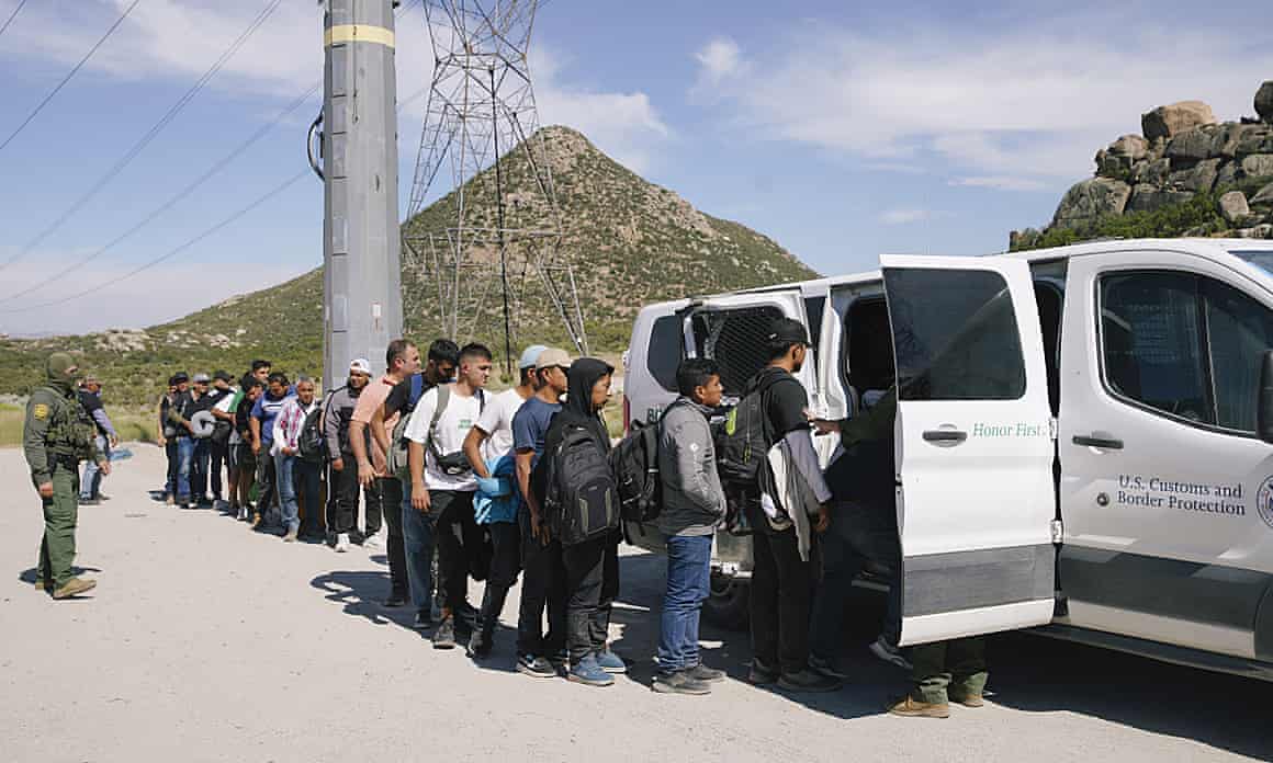 People queue up beside a white van