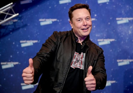 Elon Musk poses with both thumbs up.